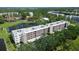Aerial view of a low-rise condo complex surrounded by lakes, lush trees, and other buildings at 5920 80Th N St # 107, St Petersburg, FL 33709