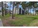 Multi-story condo building, surrounded by a large grassy lawn and mature pine trees at 5920 80Th N St # 107, St Petersburg, FL 33709