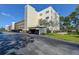 Condominium building featuring a covered parking area and well-maintained landscaping at 5920 80Th N St # 107, St Petersburg, FL 33709
