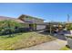 Inviting townhome featuring a covered carport, verdant landscaping, and a well-maintained lawn at 6902 El Centro Ct, Tampa, FL 33634