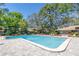 Large community pool with a brick paver deck, ladders, and a glimpse of the clubhouse at 6902 El Centro Ct, Tampa, FL 33634