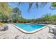 Community pool surrounded by brick pavers with ample seating and lush landscaping on a sunny day at 6902 El Centro Ct, Tampa, FL 33634