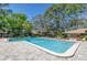 Large community pool with a brick paver deck, ladders, and a glimpse of the clubhouse at 6902 El Centro Ct, Tampa, FL 33634