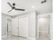 Bright bedroom featuring a ceiling fan, two closets, and marble-style tile flooring at 7412 Gulf Breeze Cir, Hudson, FL 34667