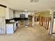 Renovated kitchen with white cabinets, black backsplash, tile flooring, and exposed framing at 8537 Horizon Ln, Hudson, FL 34667