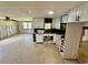Well-lit kitchen featuring white cabinets, tile flooring, and an open layout leading into other rooms at 8537 Horizon Ln, Hudson, FL 34667
