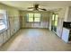 Open-concept living area with tile floors, a ceiling fan, exposed framing, and sliding door access at 8537 Horizon Ln, Hudson, FL 34667