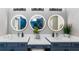 Modern bathroom with double sinks, lighted mirrors, and stylish blue vanity at 901 Eagle Ln, Apollo Beach, FL 33572