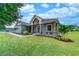 Inviting single-story home featuring a covered entry with wooden pillars and lush landscaping on a well-manicured lawn at 901 Eagle Ln, Apollo Beach, FL 33572