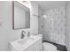 Modern bathroom with updated vanity, frameless mirror, and geometric tile in the shower at 921 7Th Nw St, Largo, FL 33770