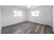 Light-filled bedroom with wood-look floors, neutral walls and two windows at 921 7Th Nw St, Largo, FL 33770