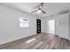 Bright living room featuring laminate flooring, a ceiling fan, a black front door, and fresh, white paint at 921 7Th Nw St, Largo, FL 33770