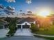 Beautiful home with palm trees, a two-car garage, and well-manicured lawn, with a sunset sky at 6927 Crestpoint Dr, Apollo Beach, FL 33572