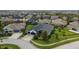 Aerial view of a home with a three-car garage, manicured lawn, and lush landscaping at 6927 Crestpoint Dr, Apollo Beach, FL 33572