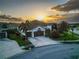 Beautiful home with palm trees, a two-car garage, and well-manicured lawn, with golden sunset clouds at 6927 Crestpoint Dr, Apollo Beach, FL 33572