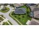 Aerial view of a home with manicured lawns, mature palm trees, fenced in backyard, and screened-in pool at 6927 Crestpoint Dr, Apollo Beach, FL 33572