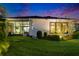 Backyard at dusk featuring a screened patio and manicured landscaping at 6927 Crestpoint Dr, Apollo Beach, FL 33572