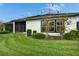 Landscaped backyard featuring a covered screened patio and manicured lawn at 6927 Crestpoint Dr, Apollo Beach, FL 33572