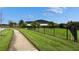 Well-manicured lawn of a large backyard with palms and black metal fence at 6927 Crestpoint Dr, Apollo Beach, FL 33572