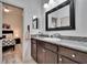 Bathroom featuring granite counter, dark cabinets, large mirror and view to the bedroom at 6927 Crestpoint Dr, Apollo Beach, FL 33572