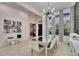 Elegant dining area features modern chandelier, mirrored table and accent furniture and decor at 6927 Crestpoint Dr, Apollo Beach, FL 33572