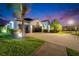 Charming two-story home boasting lush landscaping and a spacious three-car garage at twilight at 6927 Crestpoint Dr, Apollo Beach, FL 33572