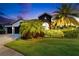 Exterior shot of a home's exterior at dusk, highlighting its lush landscaping and architecture at 6927 Crestpoint Dr, Apollo Beach, FL 33572