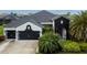 Two-story home showcasing black trim, a three-car garage and meticulous landscaping at 6927 Crestpoint Dr, Apollo Beach, FL 33572