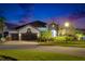 Charming two-story home boasting lush landscaping and a spacious three-car garage at twilight at 6927 Crestpoint Dr, Apollo Beach, FL 33572
