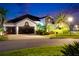 Charming two-story home boasting lush landscaping and a spacious three-car garage at twilight at 6927 Crestpoint Dr, Apollo Beach, FL 33572