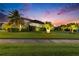 A manicured lawn in the front yard is accented with palm trees and landscaping lights, enclosed by a black metal fence at 6927 Crestpoint Dr, Apollo Beach, FL 33572