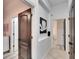 Bright hallway featuring tile flooring and access to multiple rooms with black hardware at 6927 Crestpoint Dr, Apollo Beach, FL 33572