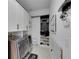 Modern laundry room featuring front load washer and dryer, white cabinets, and organization system at 6927 Crestpoint Dr, Apollo Beach, FL 33572