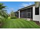 Screened-in patio and manicured lawn featuring lush landscaping and privacy at 6927 Crestpoint Dr, Apollo Beach, FL 33572