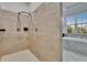 Bright, tiled shower with a modern multi-head system, next to a large window with a view of the neighborhood at 6927 Crestpoint Dr, Apollo Beach, FL 33572