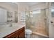 Bathroom with a glass shower, single sink, a marble countertop, wood cabinets, and a large mirror at 1010 Blue Heron Way, Tarpon Springs, FL 34689