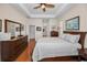 Bedroom featuring a tray ceiling, a ceiling fan, hardwood floors, and ample storage space at 1010 Blue Heron Way, Tarpon Springs, FL 34689