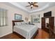 Comfortable bedroom with a tray ceiling, a ceiling fan, a window with blinds, and classic furnishings at 1010 Blue Heron Way, Tarpon Springs, FL 34689