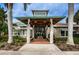 Community clubhouse entrance featuring a covered walkway, concrete pillars and tropical landscaping at 1010 Blue Heron Way, Tarpon Springs, FL 34689