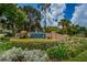 Beautiful Pointe Alexis community sign surrounded by colorful tropical plants and flowers at 1010 Blue Heron Way, Tarpon Springs, FL 34689