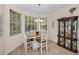 Dining area with a table, four chairs, a chandelier, and a hutch in front of a bay window at 1010 Blue Heron Way, Tarpon Springs, FL 34689