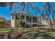 Exterior view of the home's screened porch, set in a beautifully landscaped yard at 1010 Blue Heron Way, Tarpon Springs, FL 34689