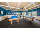 Vibrant game room with two billiards tables, pendant lighting, and a wet bar for refreshments at 1010 Blue Heron Way, Tarpon Springs, FL 34689