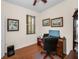 A home office featuring hardwood floors, a desk and chair, a computer, and an arched window with blinds at 1010 Blue Heron Way, Tarpon Springs, FL 34689