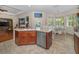 Bright kitchen featuring an island with a sink, stainless steel dishwasher, and a dining area with large windows at 1010 Blue Heron Way, Tarpon Springs, FL 34689
