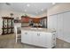 Bright kitchen with white island, stainless appliances, and dark wood cabinets at 1010 Blue Heron Way, Tarpon Springs, FL 34689