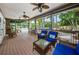 Comfortable covered patio with wicker furniture and blue cushions overlooking a pool area with lush greenery at 1010 Blue Heron Way, Tarpon Springs, FL 34689