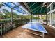 Outdoor recreation area features a ping pong table, with views of the pool and surrounding landscaping at 1010 Blue Heron Way, Tarpon Springs, FL 34689