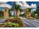 An entrance with palm trees, flowers, and a beautiful architectural design welcomes visitors to this stunning community at 1020 New Winsor Loop # 46, Sun City Center, FL 33573