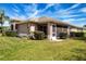Back exterior view of the home featuring a screened-in patio and manicured landscaping at 1020 New Winsor Loop # 46, Sun City Center, FL 33573